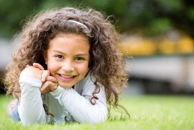 girl laying in the grass | dentist Decatur, IL