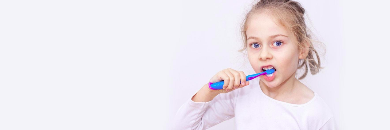 Young girl brushing her teeth l Prevent gum disease Decatur IL