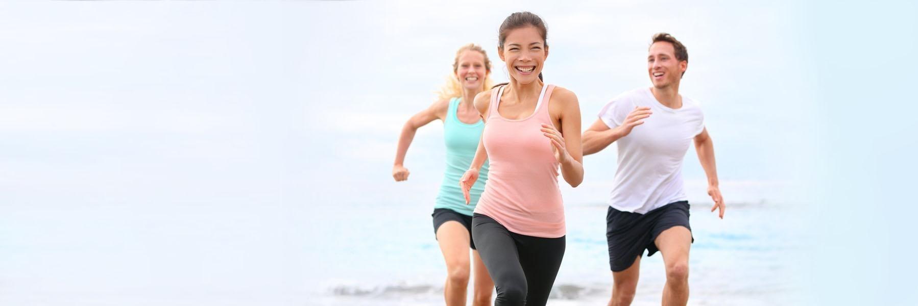 Woman & two men running on a beach after general Dentistry at Jerger Pediatric Dentistry