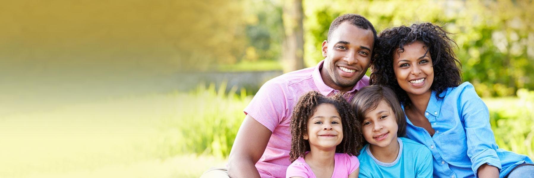 Family of four smiling after teeth cleaning in Decatur, IL