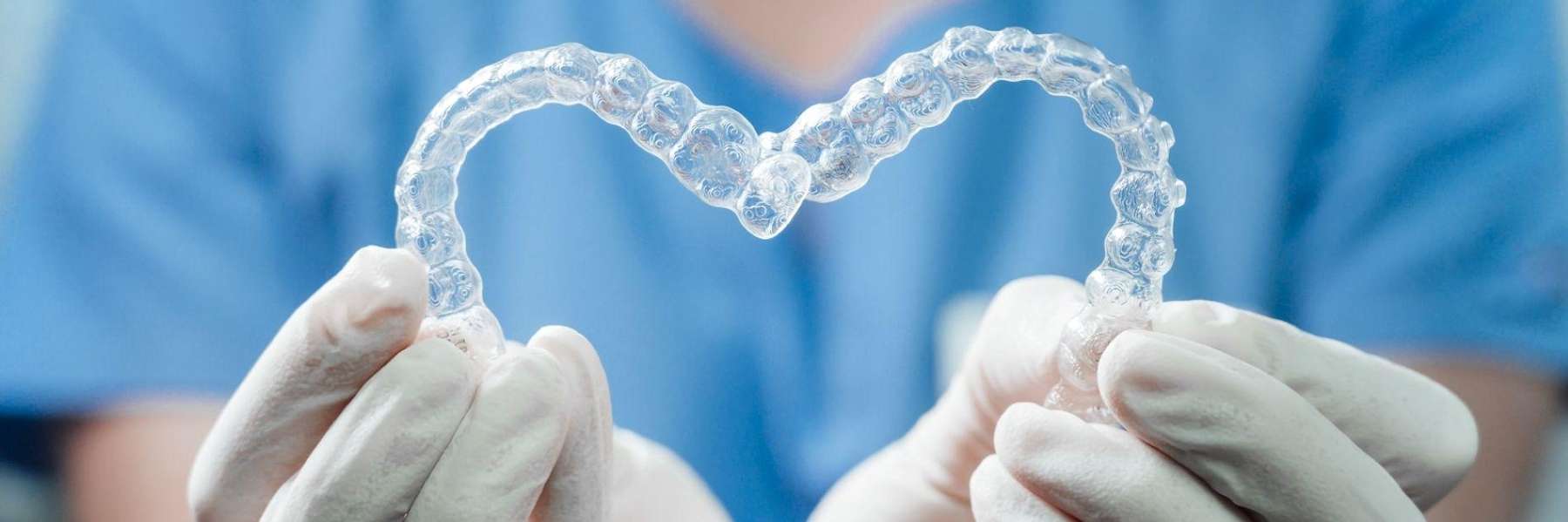 A dentist holding two Invisalign in Decatur, IL