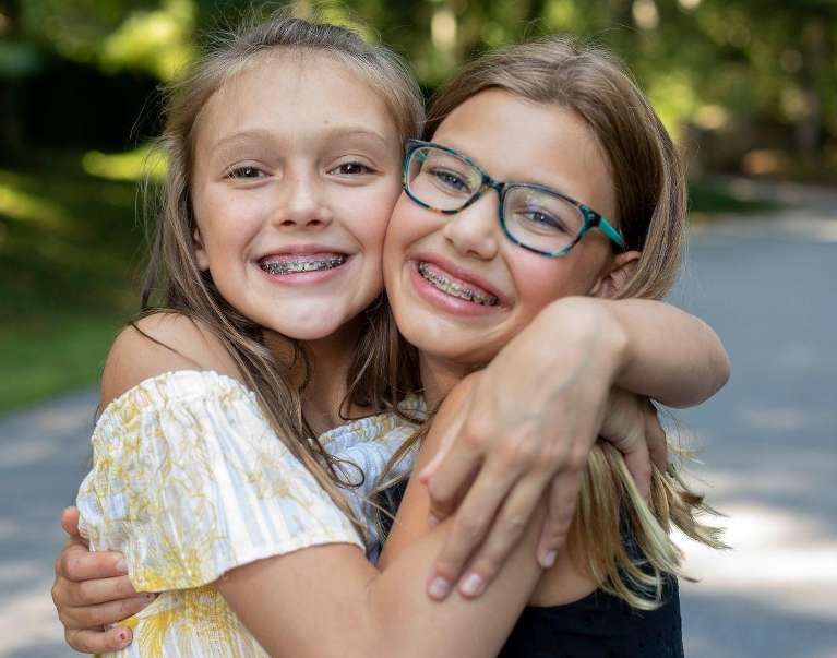 Two girls with braces hugging in Decatur, IL