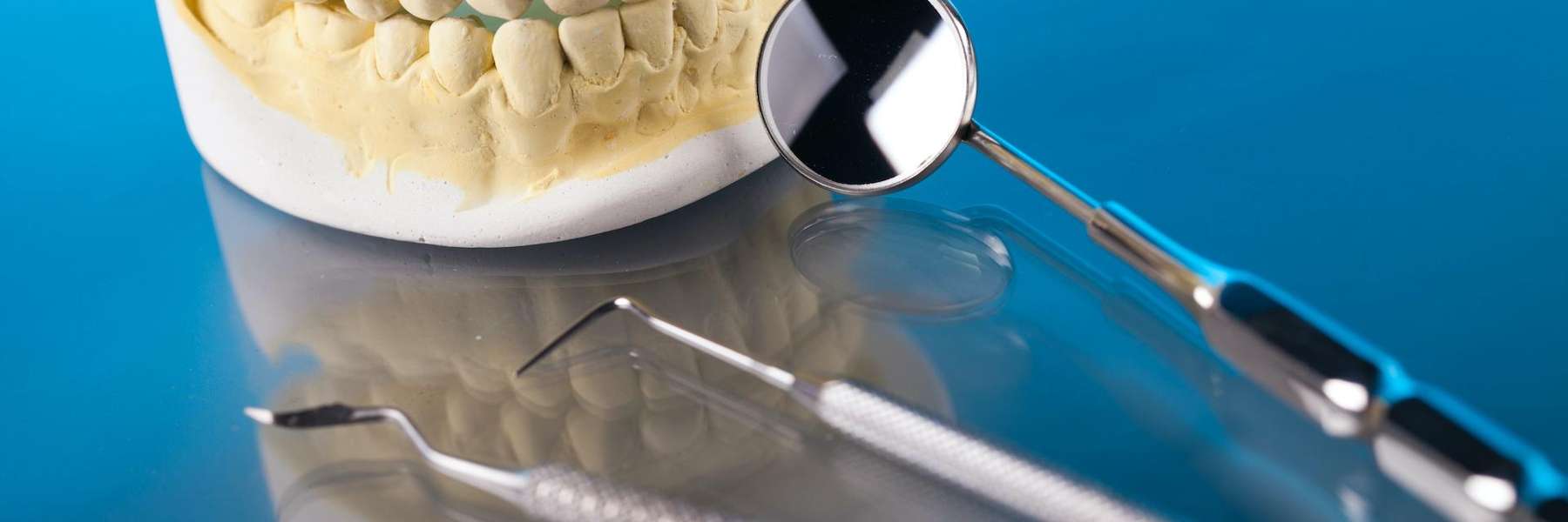 A picture of a dental crown and teeth extraction tools in Decatur, IL